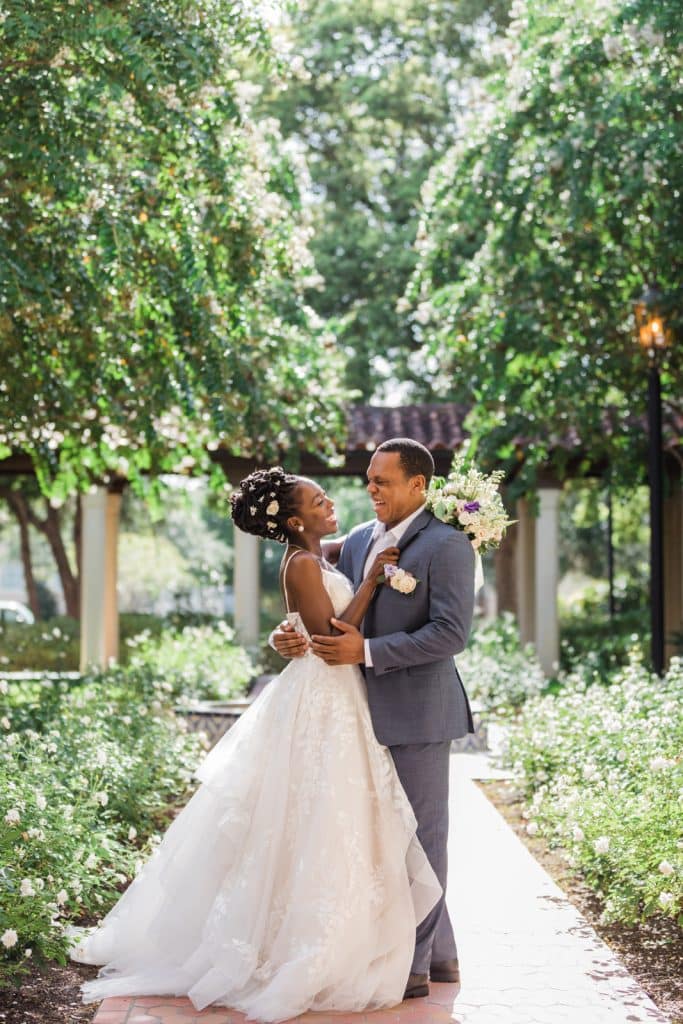 bride and groom embracing on a tree lined path photographed by Ashley Jane Photography