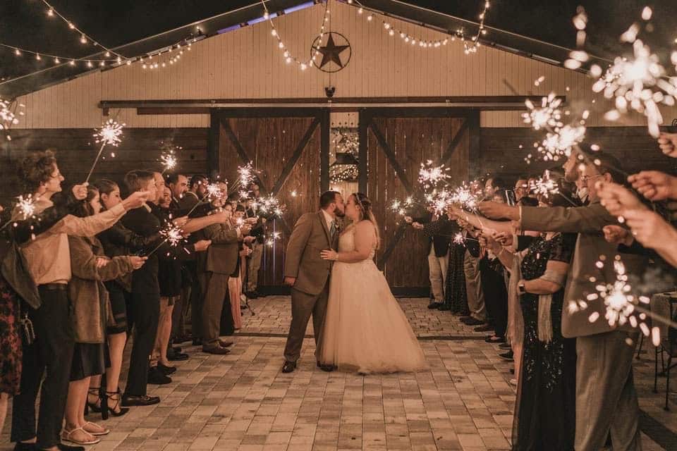 bride and groom leaving at the Rocking L Ranch Wedding Barn under sparkler arch