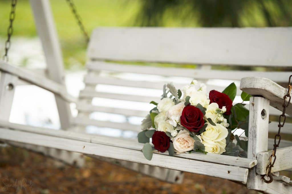 white wooden swing with roses bouquet at the Rocking L Ranch Wedding Barn