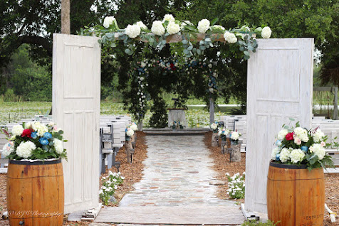 walkway to hydrangea covered gazebo with wooden barrel aisle markers at the Rocking L Ranch Wedding Barn