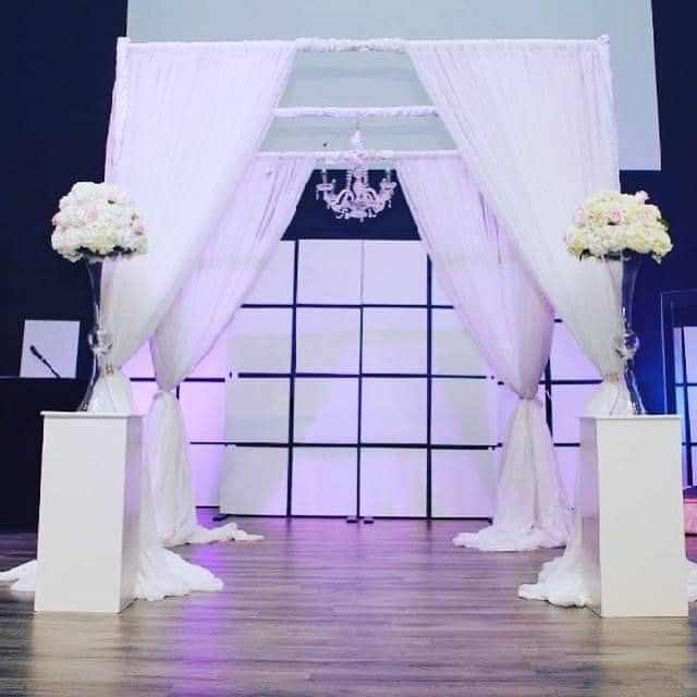 wedding ceremony with pillars and tall floral pieces coordinated by glameventdesigns