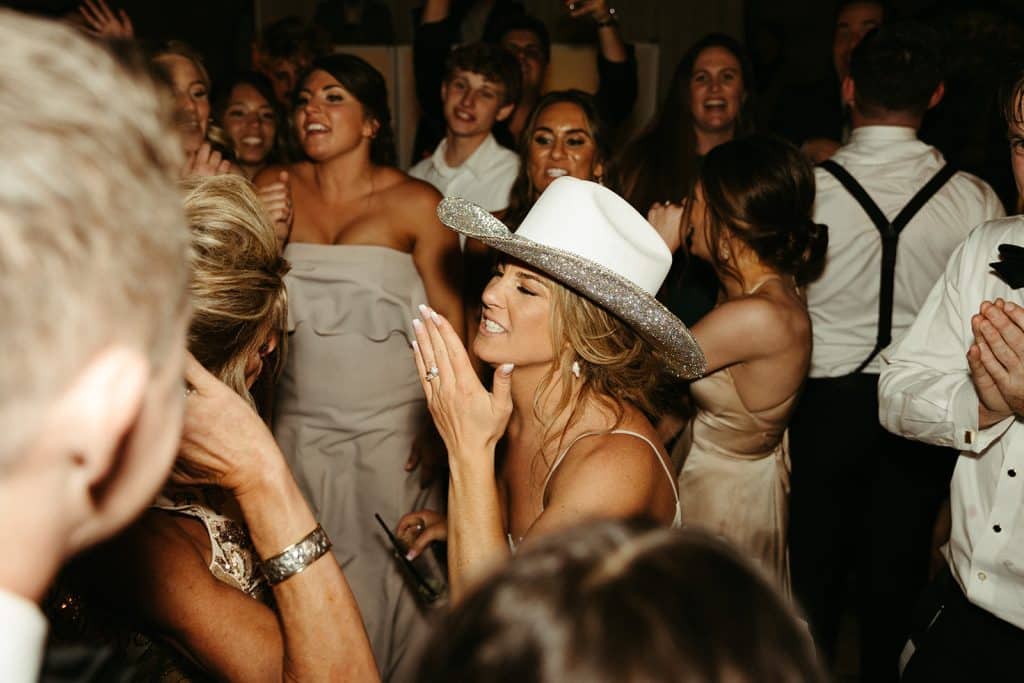 beautiful woman with white fedora blowing a kiss on the dance floor