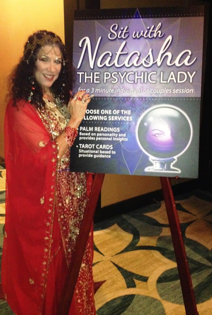 The Psychic Lady standing in front of poster announcing her presence