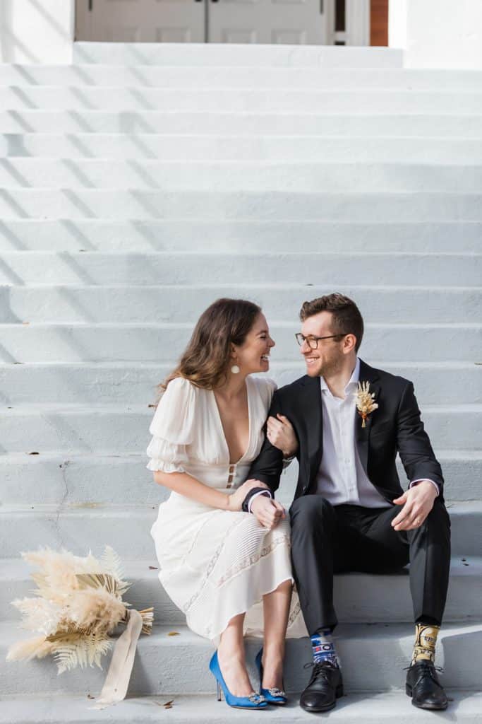 bride and groom sharing quiet moment sitting on steps photographed by Ashley Jane Photography