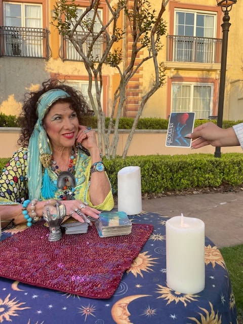 The Psychic Lady sitting outside and pulling tarot cards for a reading