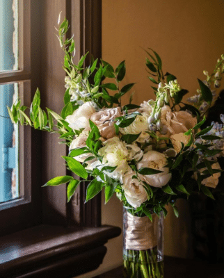 Wedding bouquet with pink and white flowers, held together with pink ribbon, standing next to a window on a table, Orlando, FL