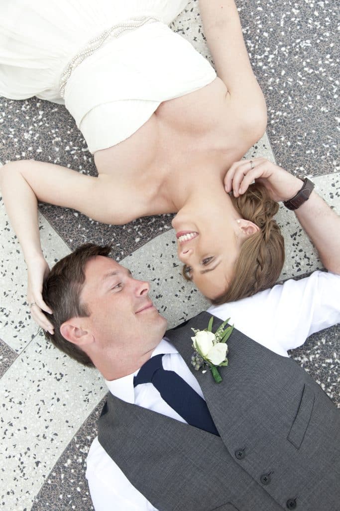 bride and groom on grey cement pavers in grey and white photo by Evan Hampton Photography