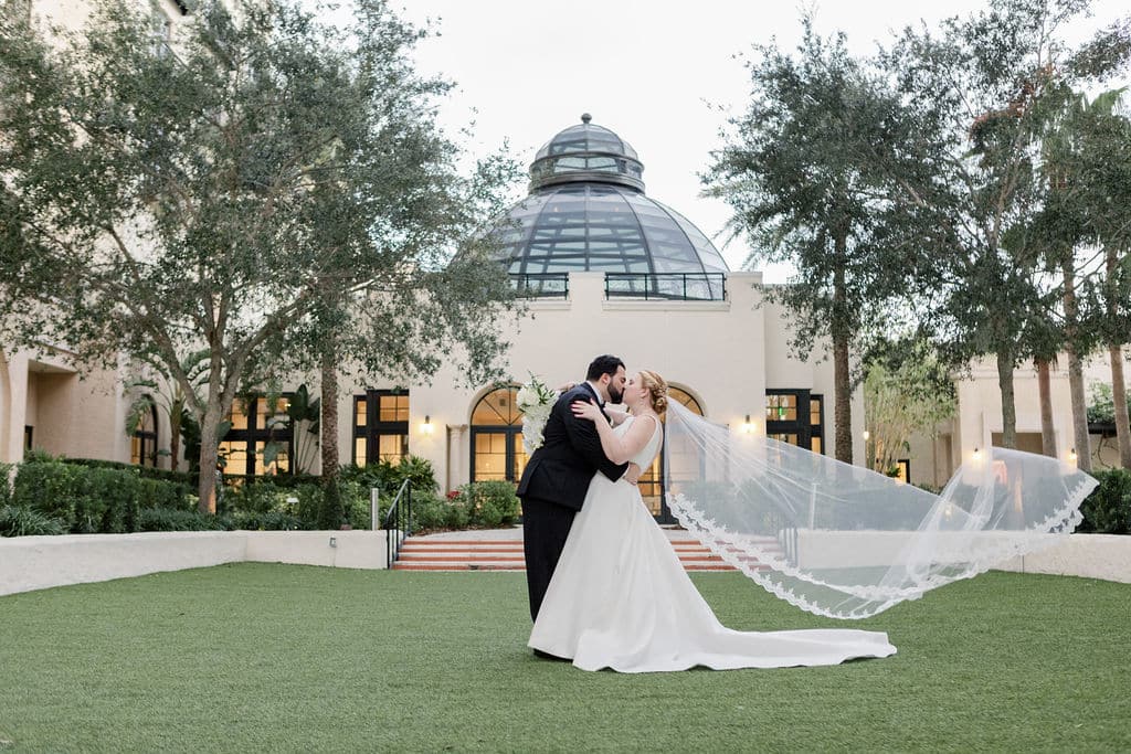 bride and groom kissing outdoor in front of rotunda photographed by Hundreds of Moments Photography