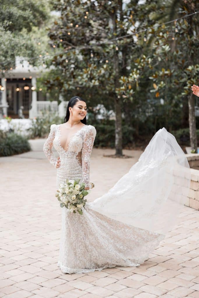 bride in brick courtyard photographed by Hundreds of Moments Photography
