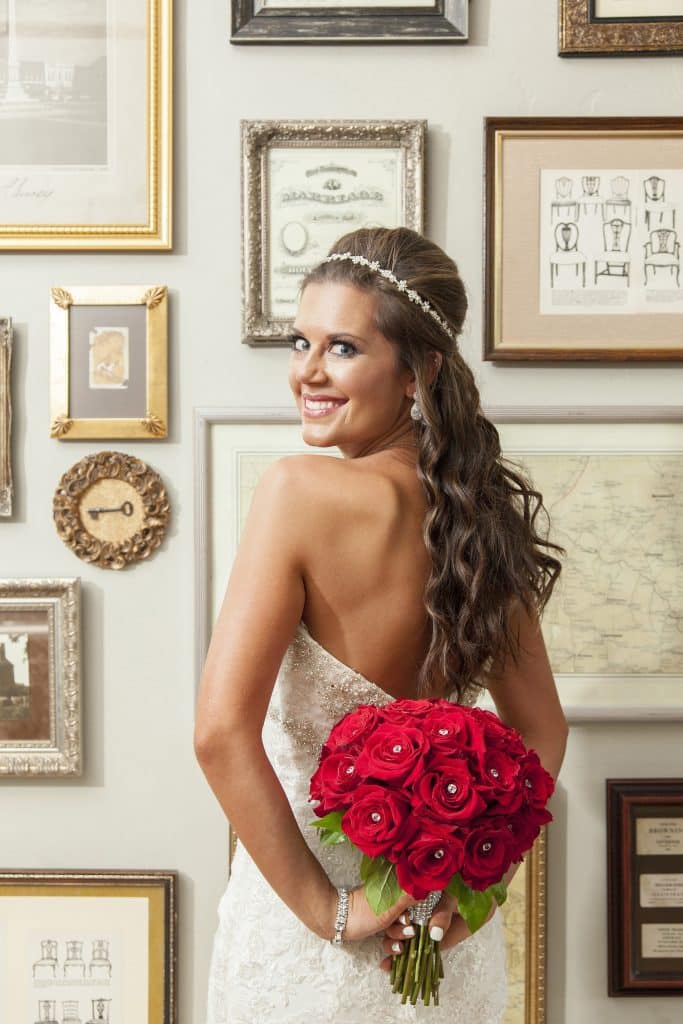 bride with red rose bouquet smiling on wedding day by Evan Hampton Photography