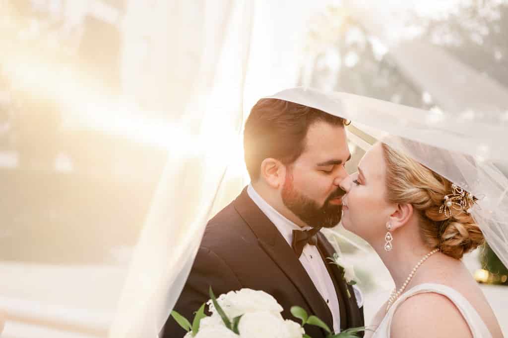 bride and groom kissing under her veil photographed by Hundreds of Moments Photography
