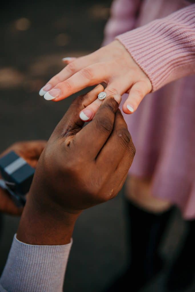 Bi-racial couple getting engaged, showing off the engagement ring during engagement photo shoot in Orlando, FL