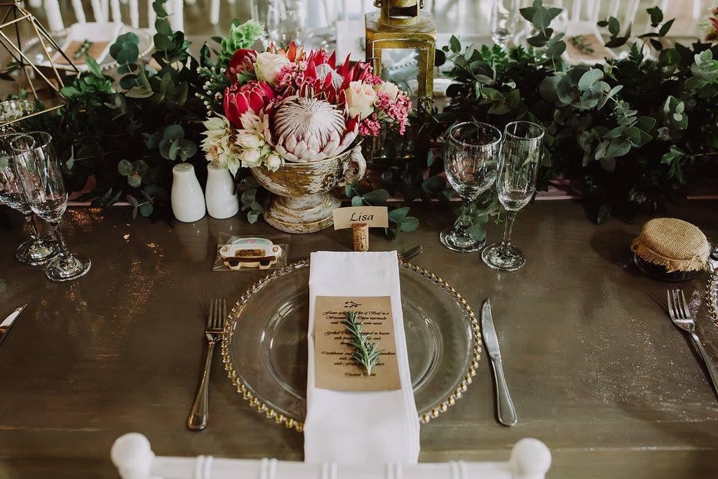 table setting with glass charger and greenery at wedding coordinated by A. Marie Events & Design