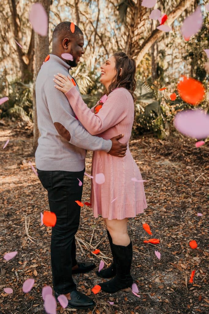 Bi-racial couple having fun at their engagement shoot in the woods by Sunshine Memories Photography in Orlando, FL