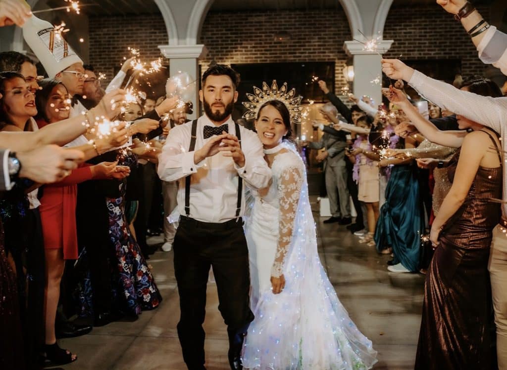bride and groom celebrating under tunnel of lights by Elite Celebrations