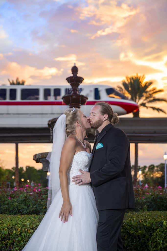 bride and groom kissing in front of the monorail at Walt Disney World photo by Evan Hampton Photography