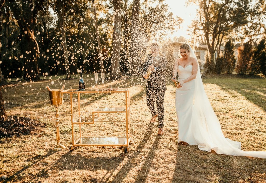 A champagne splash as a couple finalizes their ceremony outdoors in Orlando, FL, photo by Sunshine Memories Photography