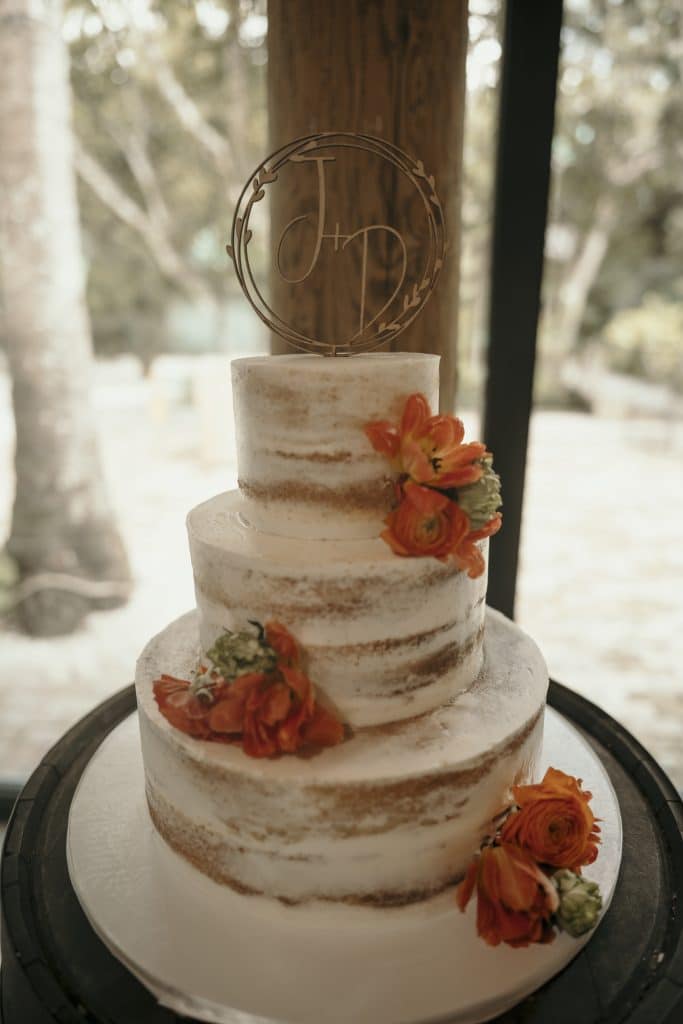 wedding cake with orange flowers at wedding reception coordinated by A. Marie Events & Design