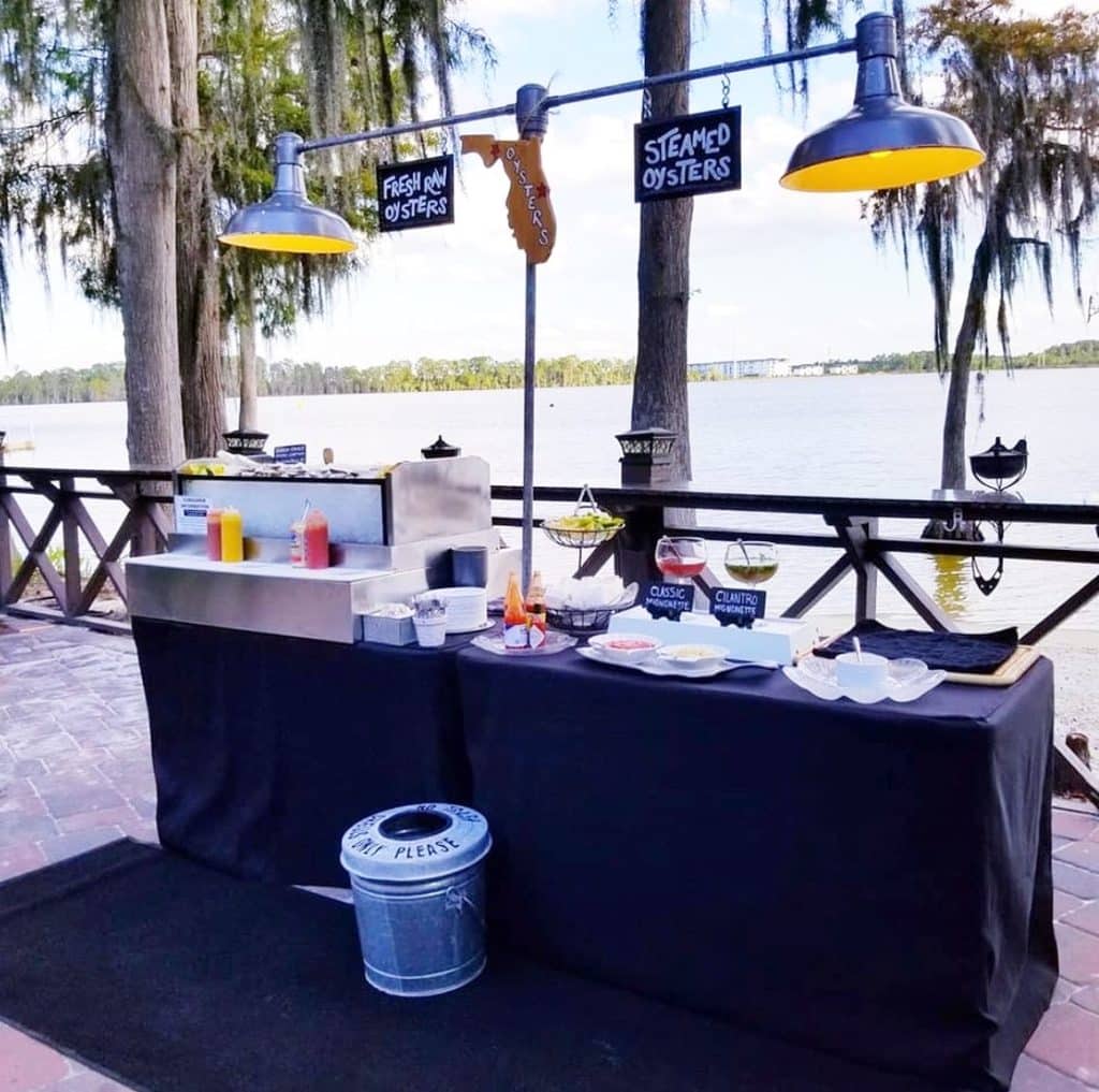Outdoor set up of an oyster bar with overhead heat lamps, cocktails and a view of the water, Orlando, FL