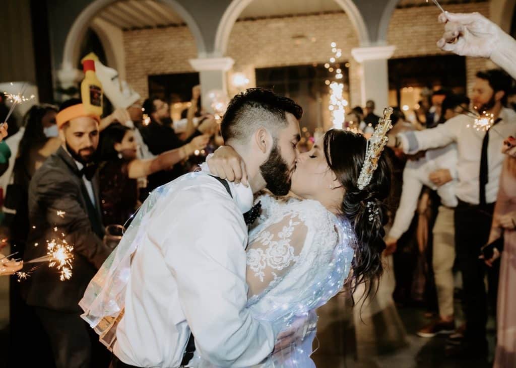 groom dipping bride for a kiss on the dance floor at wedding by Elite Celebrations
