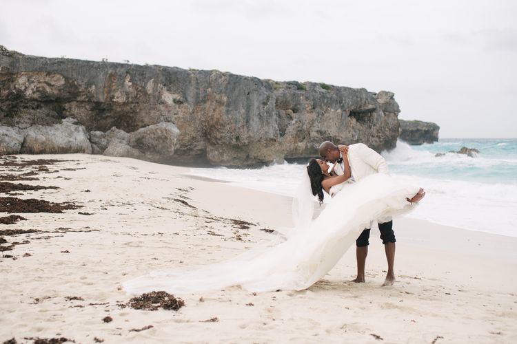 bride and groom in bare feet on the beach with cliffs in the background at wedding coordinated by A. Marie Events & Design