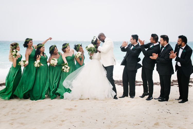 bride and groom kissing with wedding party looking on at wedding coordinated by A. Marie Events & Design