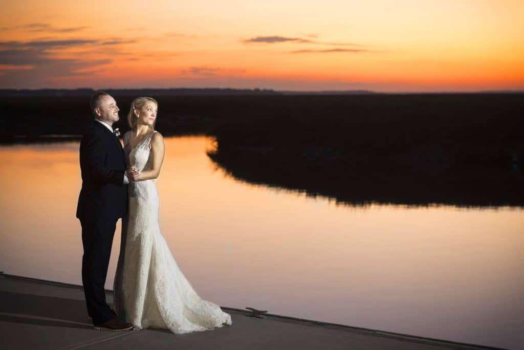bride and groom looking over waterway at the golden hour photo by Evan Hampton Photography