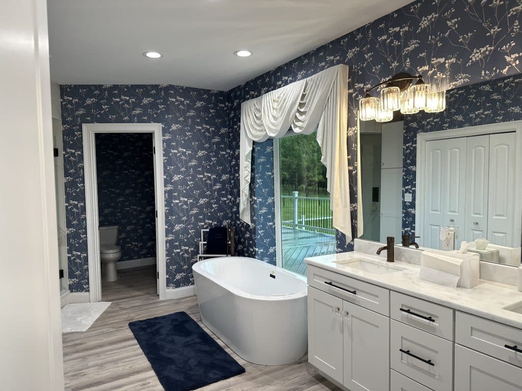 Bridal Suite Bathroom with blue wallpaper, ceramic tub, his and her sinks and a view of the outside patio, Central, FL