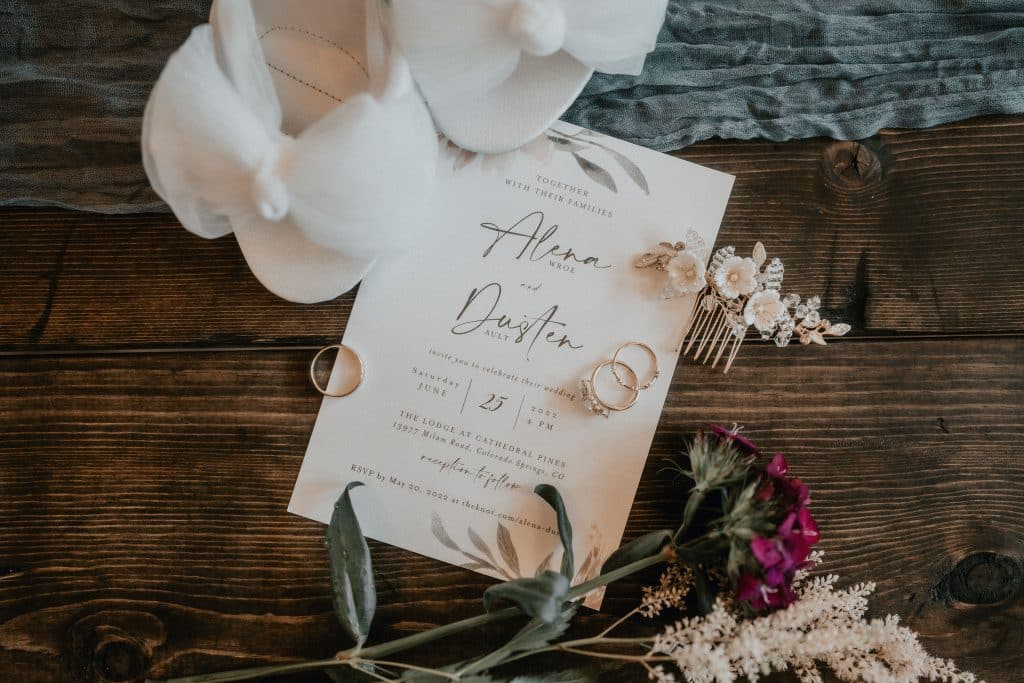 wedding flatlay of shoes, invitation and hair accessories