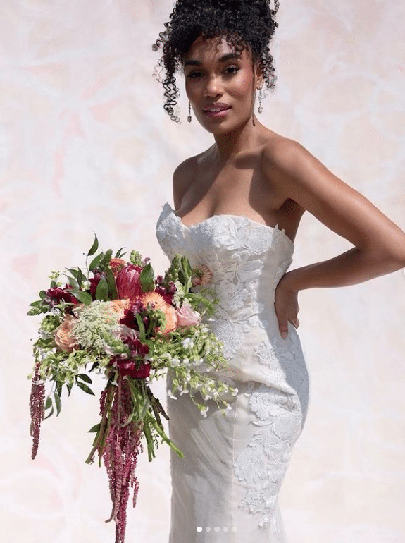 Bride in a white strapless gown, holding a floral bouquet of pink, red and white flowers with added baby's breath, Orlando, FL