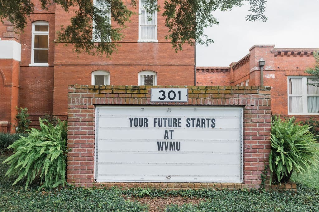 marquee sign in front of brick building with the words your future starts at wvmu