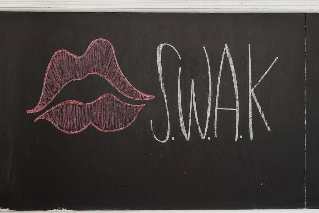 chalkboard with pink lips drawn on it and the letters SWAK