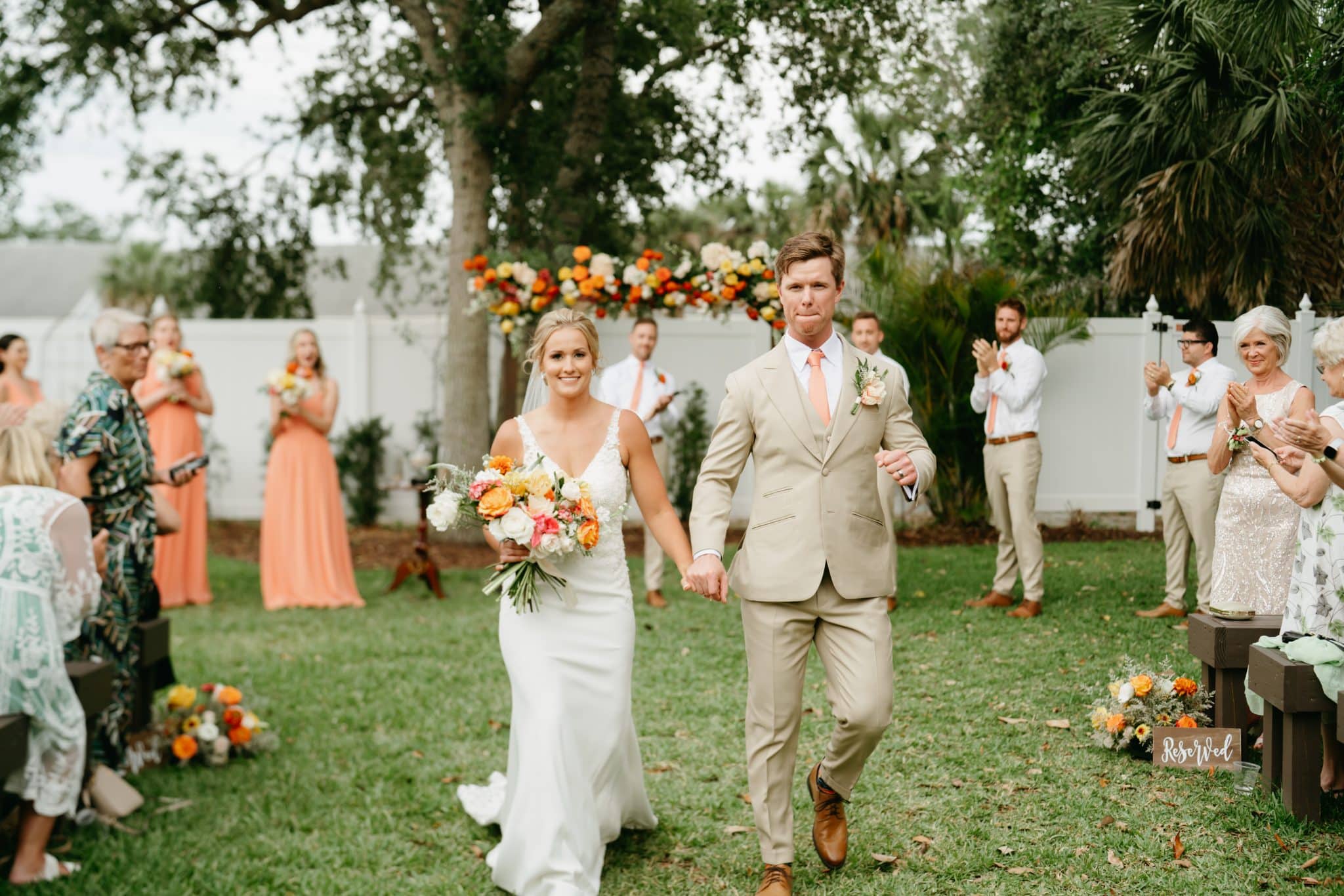 Newlyweds walk down the isle after their ceremony at charming spring wedding at The Grand Ol' Barn in New Smyrna, Florida
