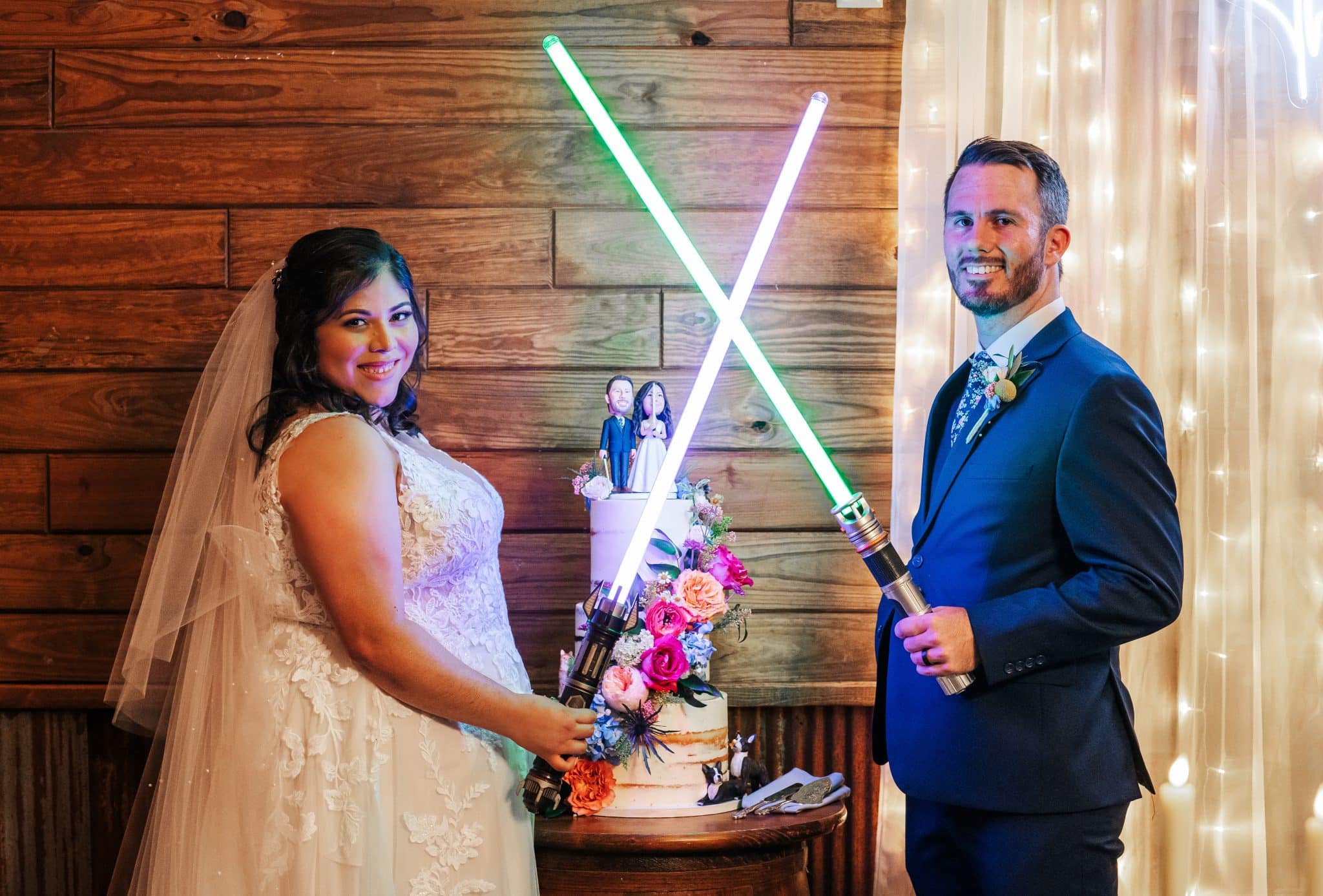whimsical wedding at Hidden Barn Venue in Apopka, FL where bride and groom hold special light sabers they used during ceremony.