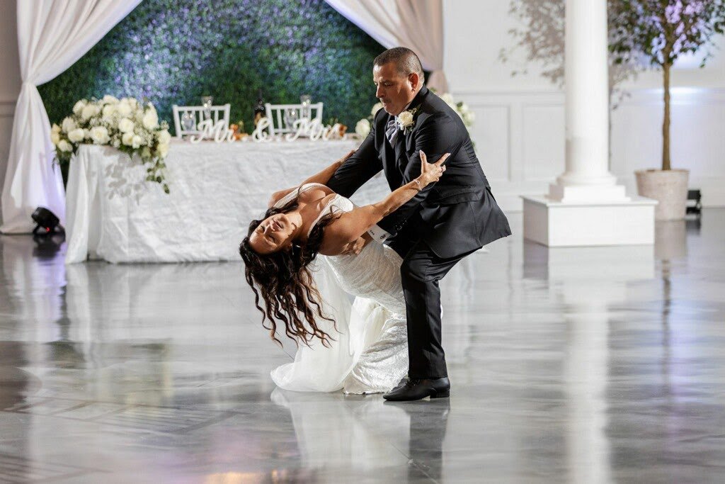 Groom dipping his bride on the dance floor, indoors at a wedding reception, Dance It Studio
