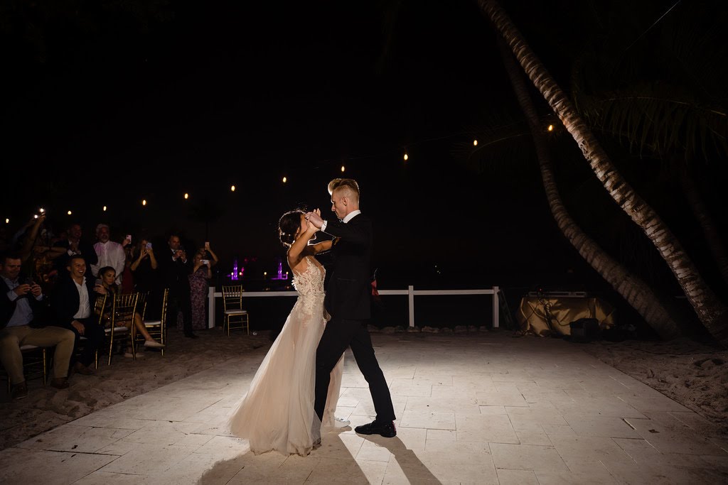 Couple dancing outdoors at a reception, with minimal lighting and a spotlight on the couple, Orlando, FL