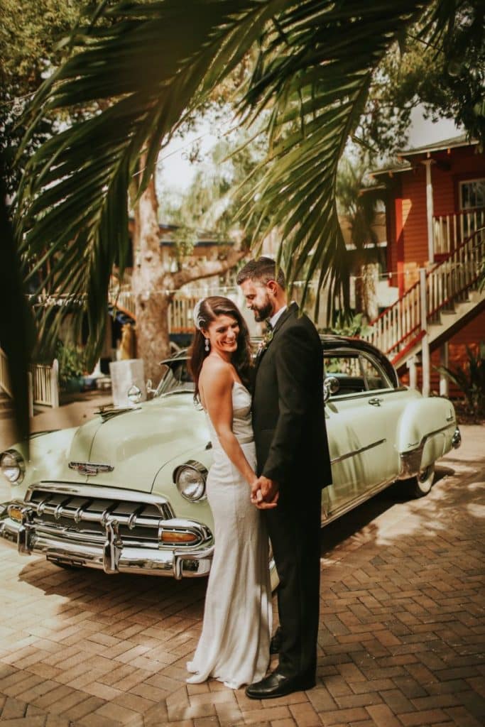Bride and Groom standing in front of a green classic car under palm trees, Central FL, The Veranda at Thornton Park
