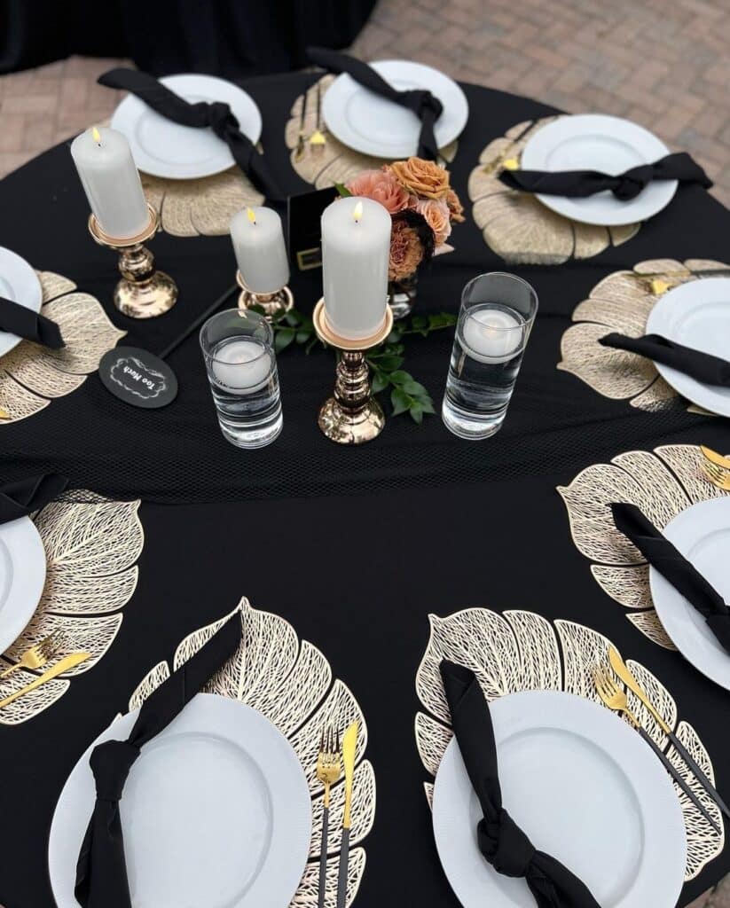 Table with black table cloth, black napkins, white chargers with candles in the center, Central, FL