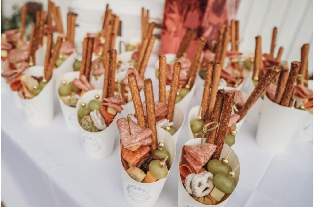 Appetizer shooters with olives, pretzels, charcuterie meats and cheese on a table with a white tablecloth, Central, FL