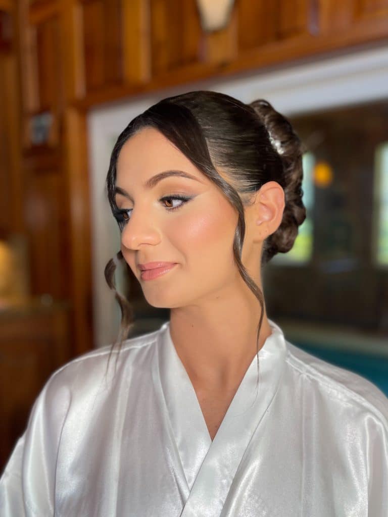 Brunette bride with soft pink make up and hair in a bun and curls shaping her face, Haley Finegan Hair and Make Up, Central FL