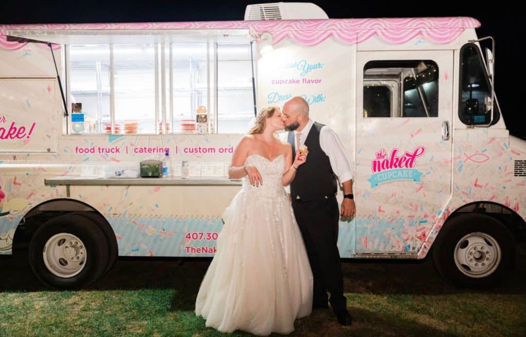 Married Couple kissing in front of the Naked Cupcake Food Truck, Central, FL