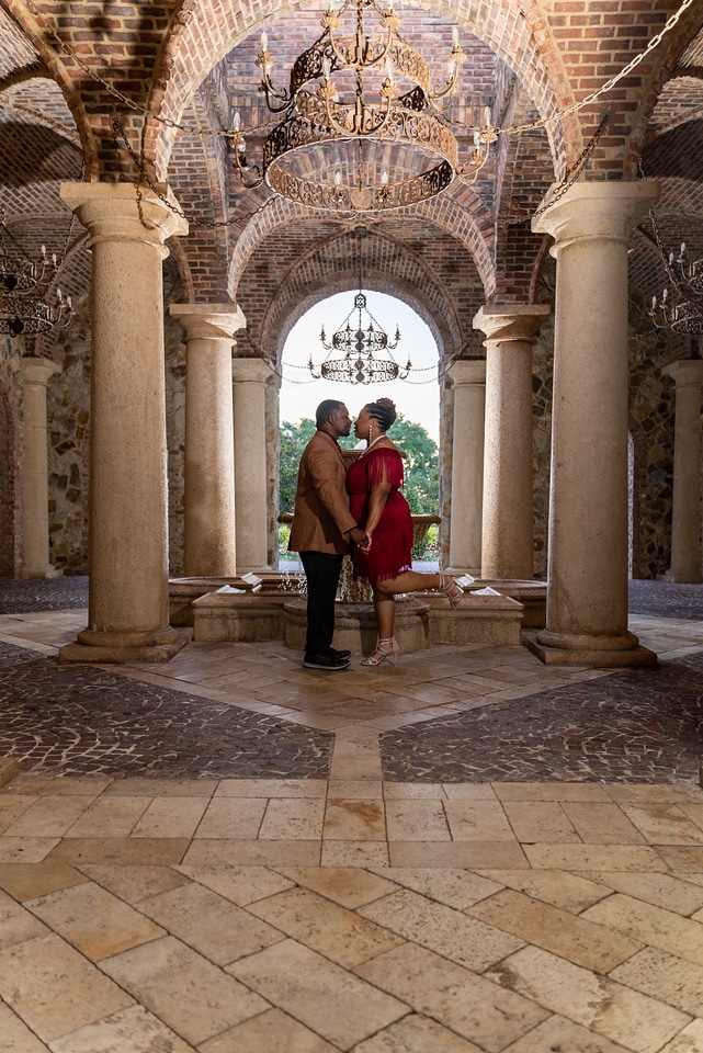 Couple facing each other and holding hands inside an ornate venue, with tiled flooring, large columns and beautifully tiled walls, Central FL