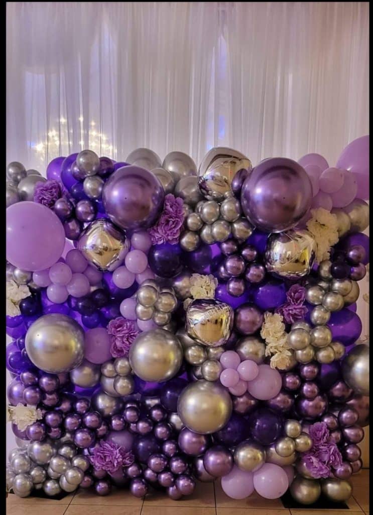 Balloon wall with silver, gold and various shades of purple balloons with a sheer white backdrop, JoJo's Glitz & Glam Event Planning, Central FL