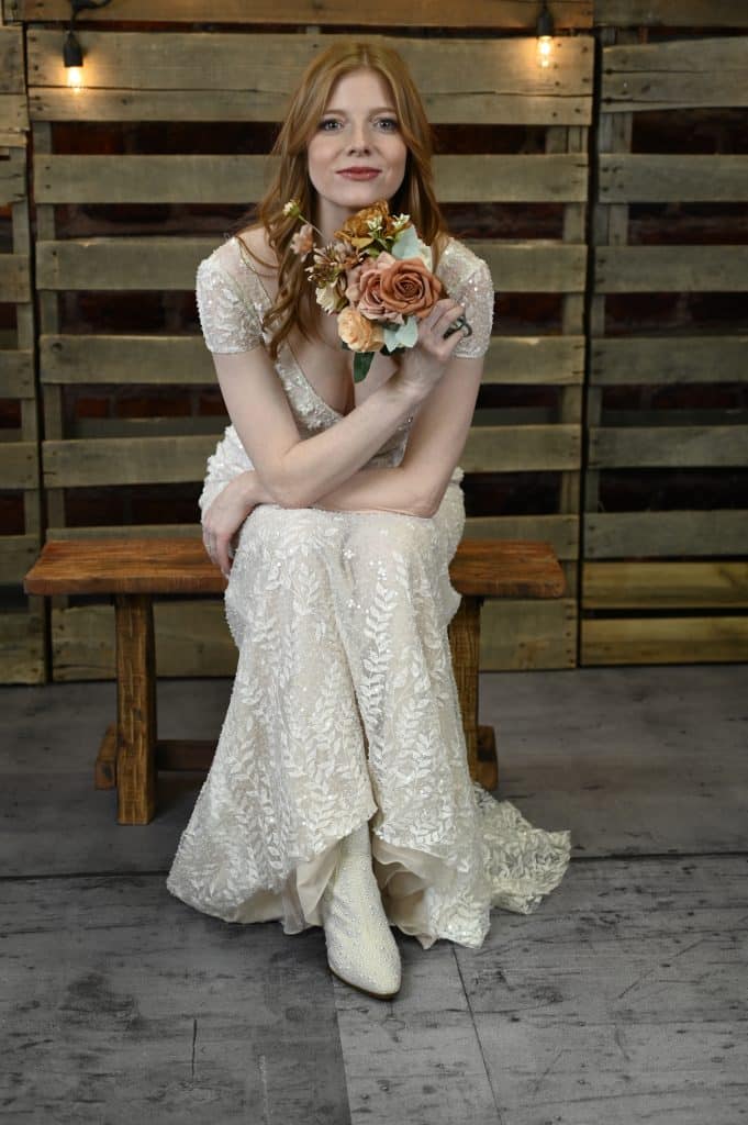 Bride sitting on a wooden bench, with her bouquet in Central, FL