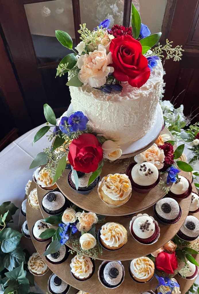 Aerial view of a Naked Cupcake tower with a one layer cake on top, covered with flowers, including red roses, Central, FL