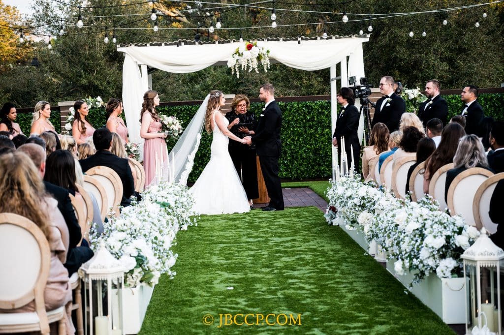 Outdoor wedding ceremony, under a white fabric alter, with guests looking on, Central, FL