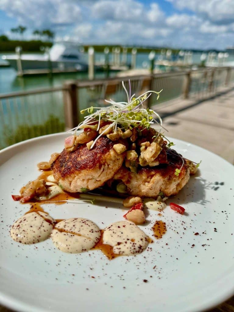 two crab cakes angled on each other with three dollops of puree, topped with greens, Outriggers Tiki Bar & Grille, Central Fl