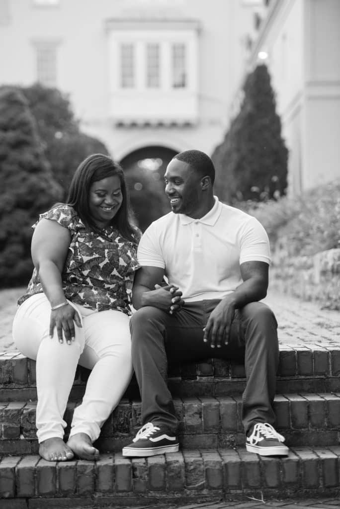 Engagement photos of a couple sitting on brick steps with a beautiful home in the background, Central FL, JB's Cinematic Creations and Photography