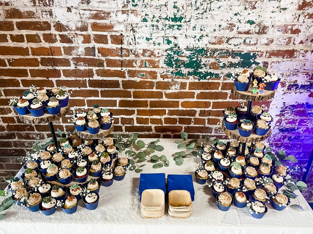 Cupcake tower displays on a table with exposed brick in the background, The Naked Cupcake, Central, FL