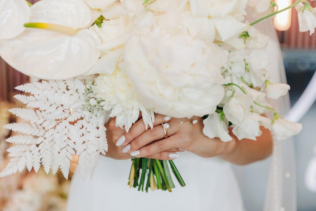 bride holding her bouquet of large white flowers with baby's breath and white accompaniments, Central FL